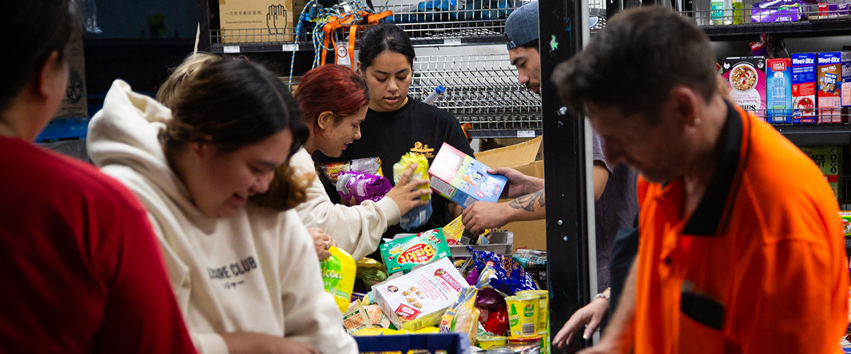 A group of volunteers working with Lighthouse Care organise groceries to assist families affected by the tropical cyclone in Queensland.
