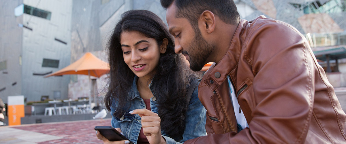 Two people look at a phone.